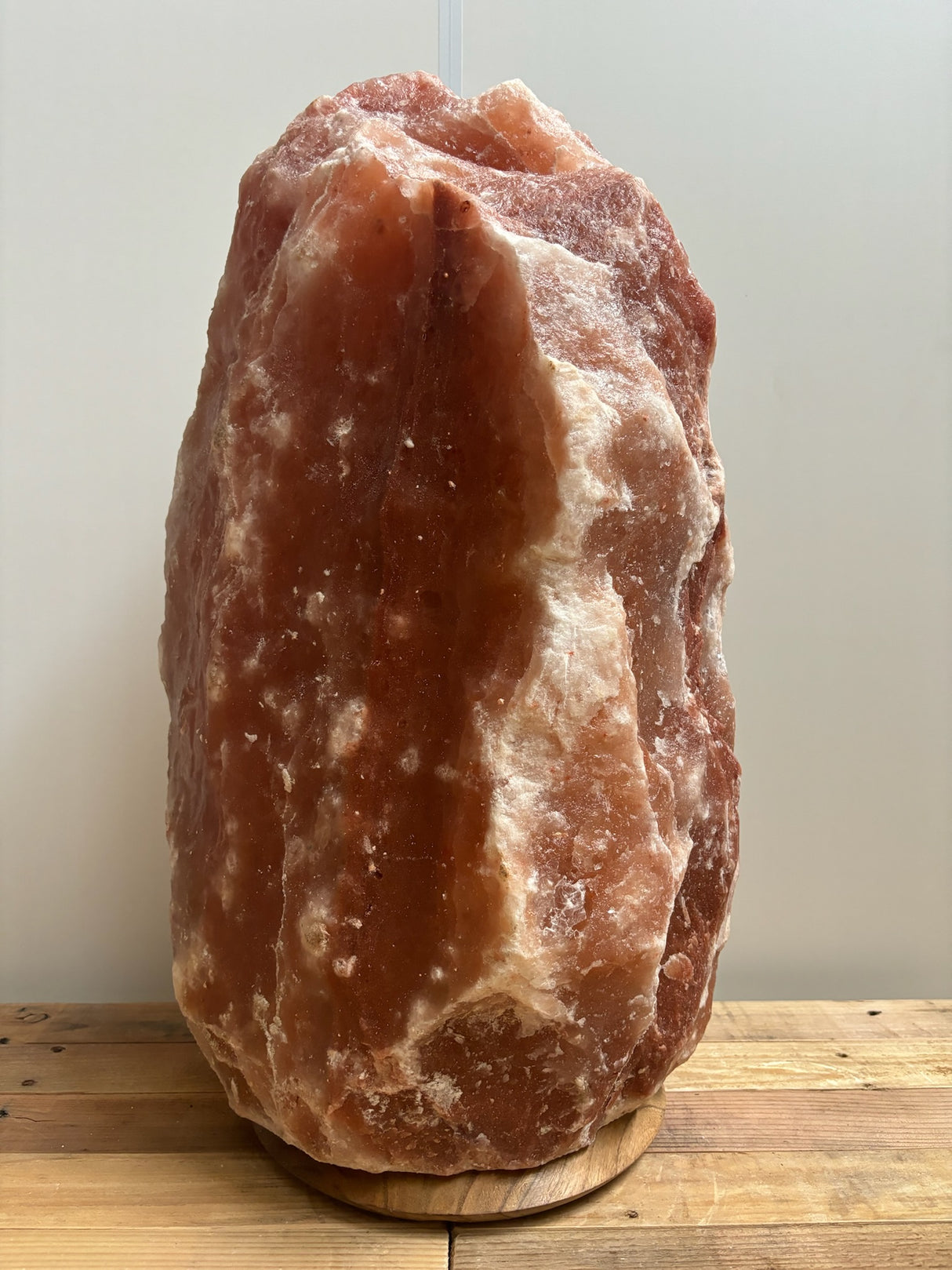 Donkere Himalaya zoutlamp 50–60 kg met natuurlijke diepe tinten op stevige houten voet