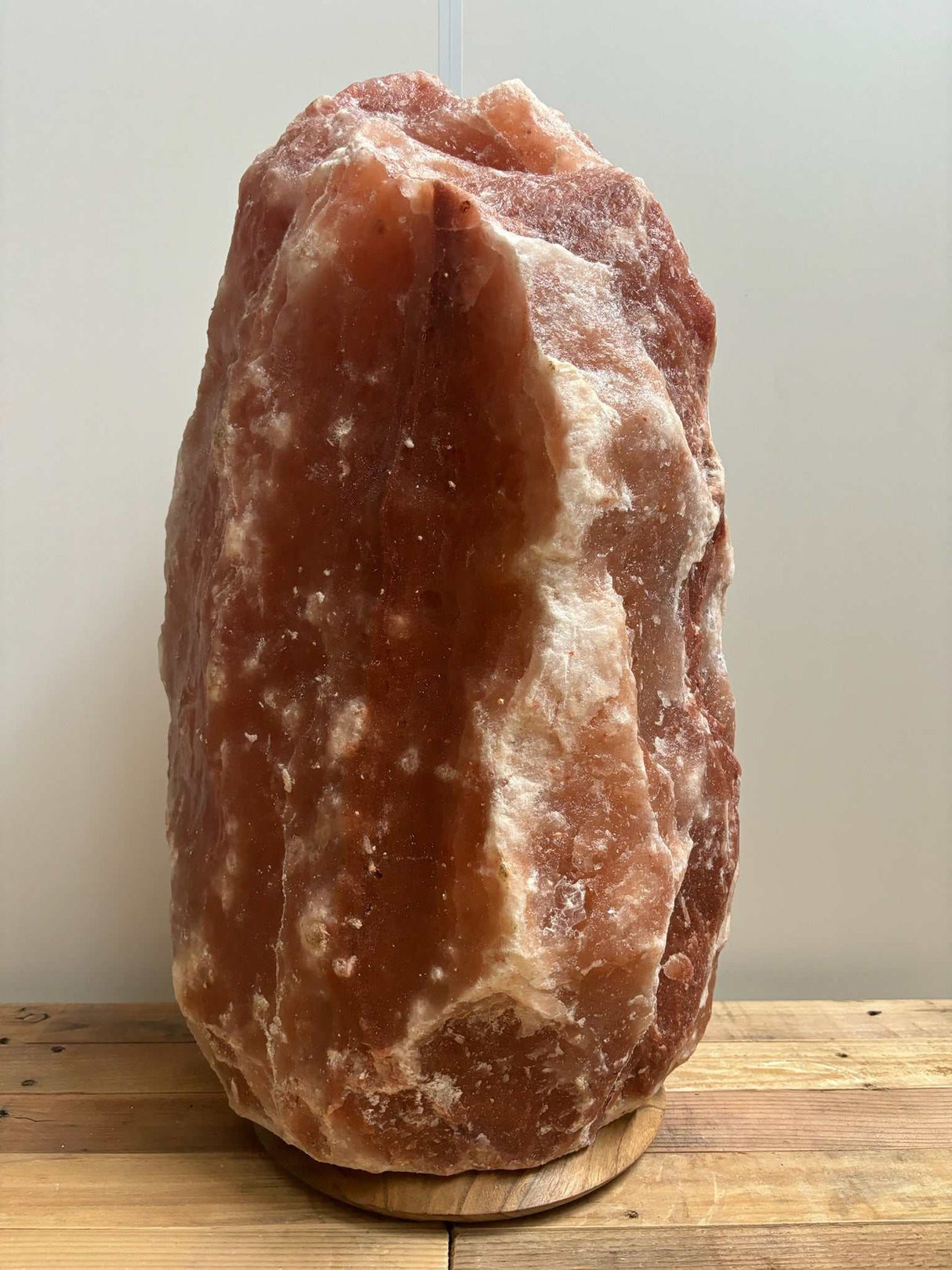 Himalaya zoutlamp rood 50–60 kg met warme rode en oranje gloed op houten voet inclusief kabel en reservelampje