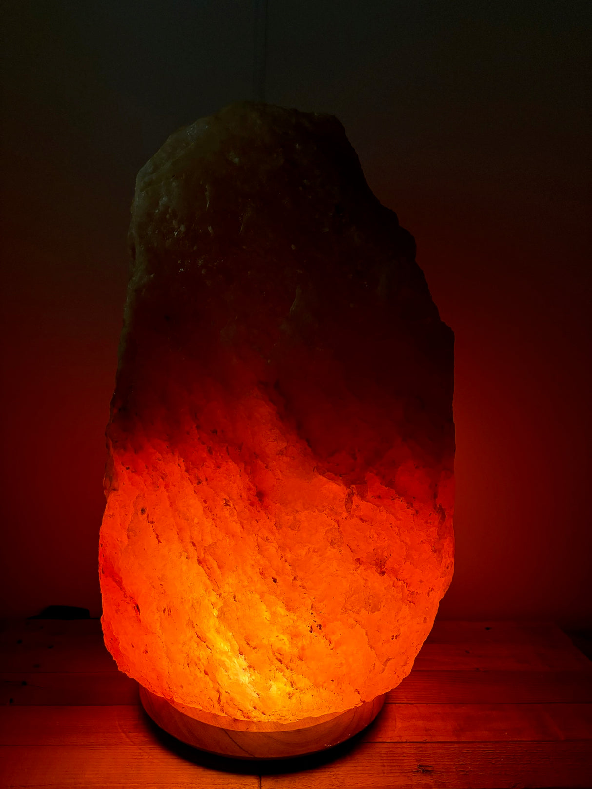 Lichte Himalaya zoutlamp 70–80 kg met warme gloed op robuuste houten voet