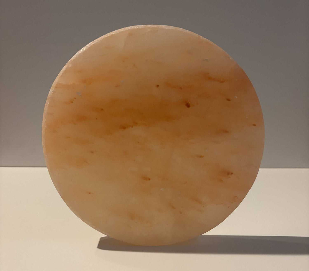 Ronde Himalaya zoutsteen tegel van 20 cm diameter met natuurlijke roze en oranje tinten.