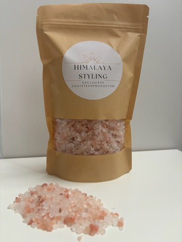Zak van 1 kg Himalaya badzout met roze kristallen (korrelgrootte 2–5 mm). Natuurlijk en mineraalrijk zout uit Pakistan, verpakt in een milieuvriendelijke, hersluitbare kartonnen zak. Geschikt voor baden, scrubs en voetenbaden ter ondersteuning van ontspanning, huidverzorging en spierherstel.