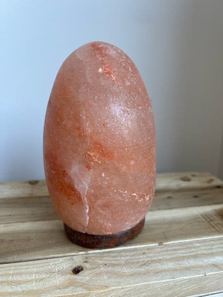 Himalaya Zoutlamp in ei-vorm van roze zoutkristal op houten voet met warm dimbaar licht
