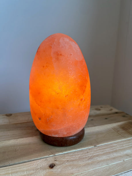 Himalaya Zoutlamp in ei-vorm van roze zoutkristal op houten voet met warm dimbaar licht