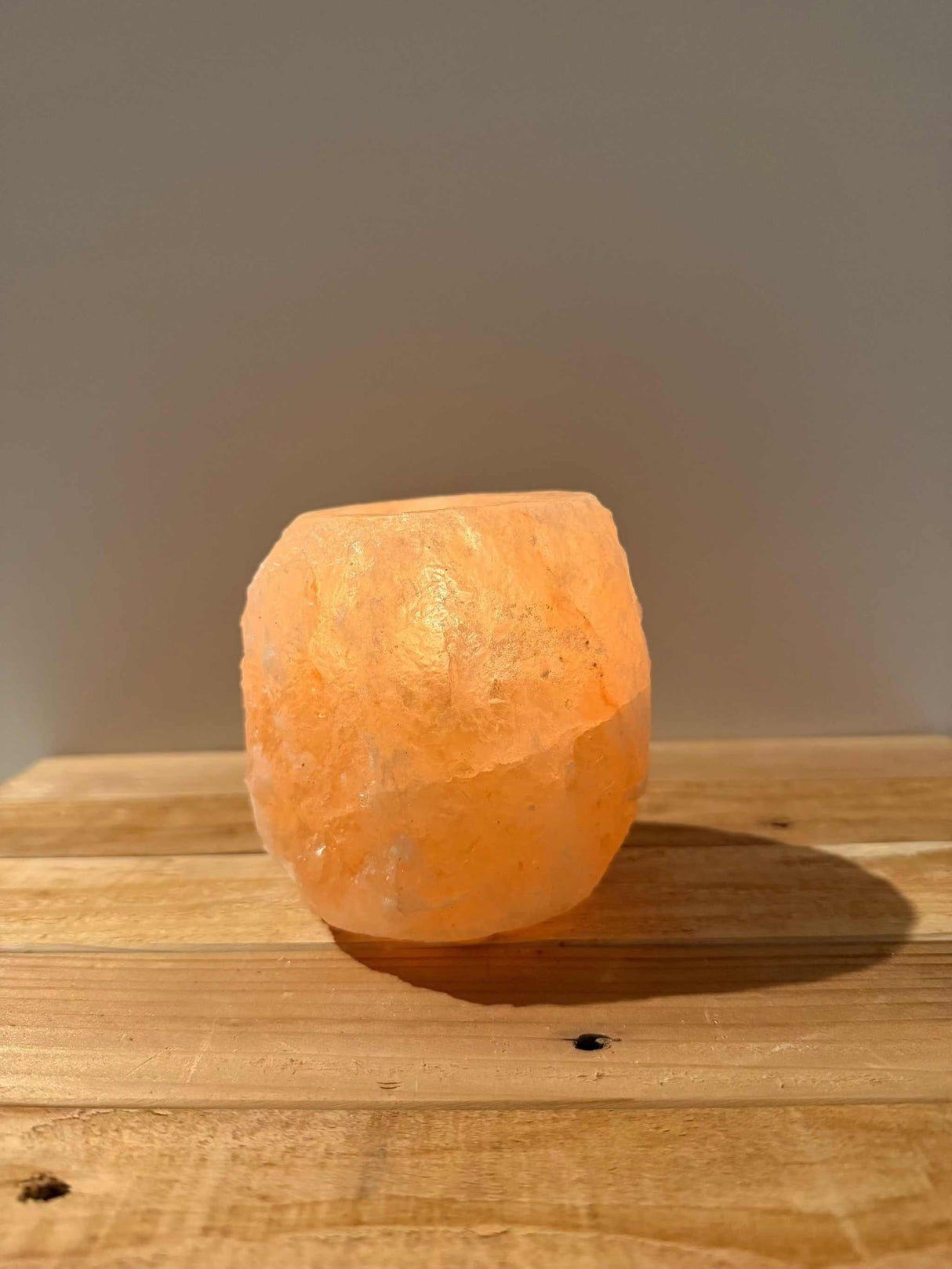 Handgemaakte roze waxinelichthouder van natuurlijke zoutsteen met warme gloed en siliconen voetjes.