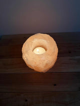 Handgemaakte roze natuurlijke zoutsteen waxinelichthouder met siliconen voetjes en zachte gloed.