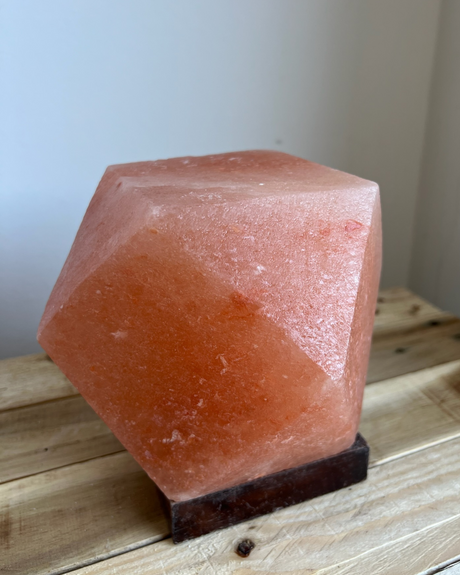 Himalaya zoutlamp in diamantvorm op houten voet, verspreidt warm licht en zuivert de lucht op natuurlijke wijze
