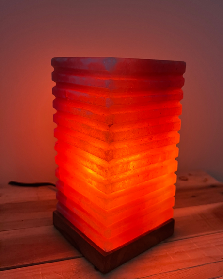 Handgemaakte spiraal zoutlamp op houten voet, zuivert lucht en straalt warm licht voor een rustgevende sfeer thuis