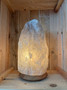 Brandende grijze Himalaya zoutlamp 4-6 kg op houten voet in een houten kist