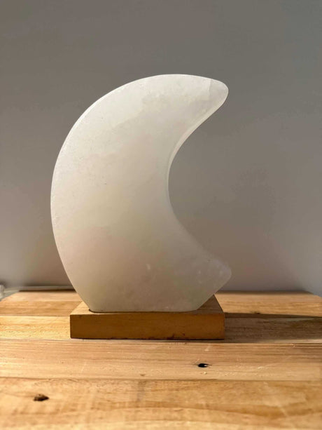 Himalaya zoutlamp in maanvorm in roze, grijs of wit met zachte, rustgevende gloed en houten voet