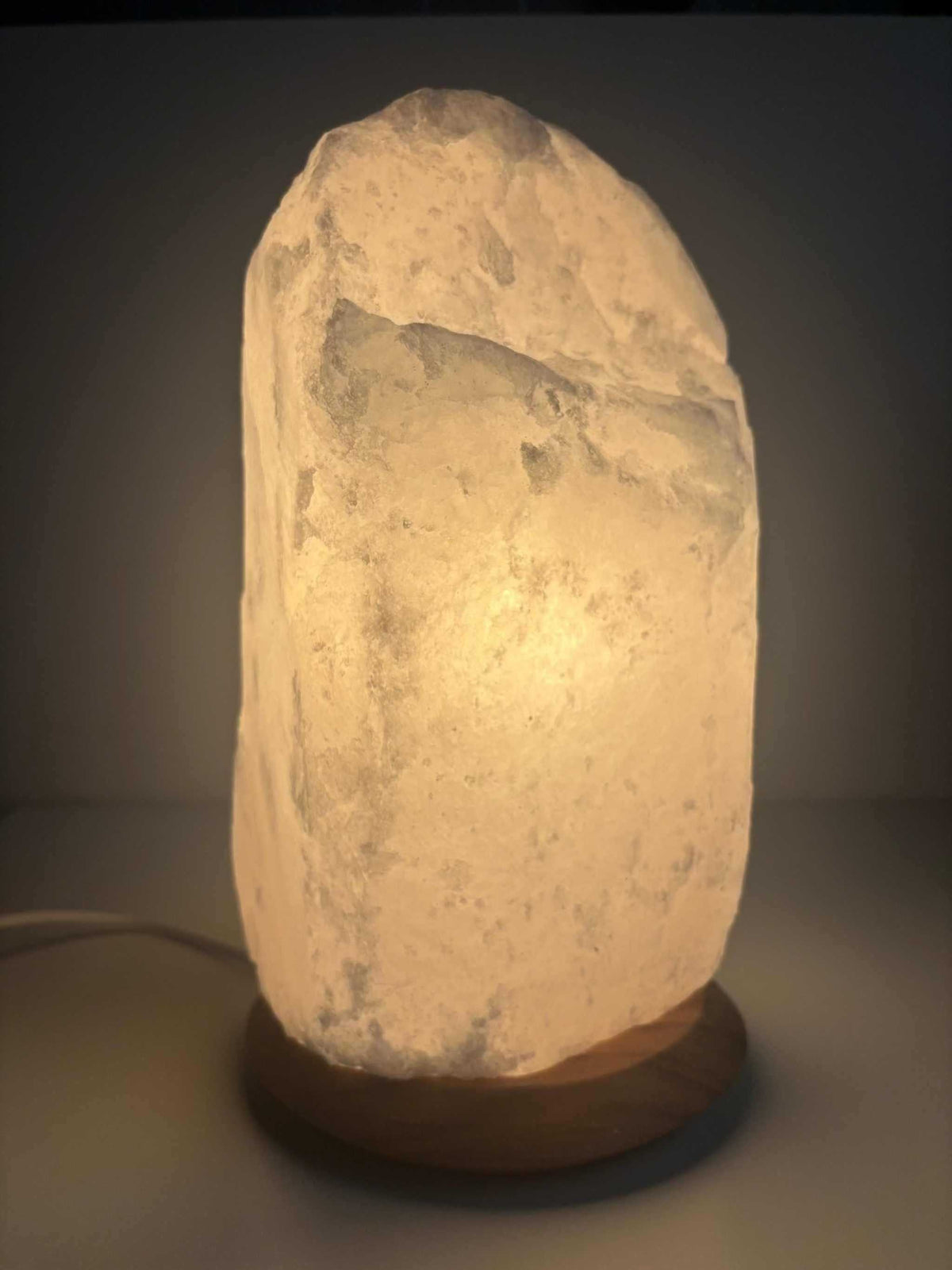 Himalaya zoutlamp wit 10-12 kg met houten voet en warm licht, inclusief snoer en lampje.