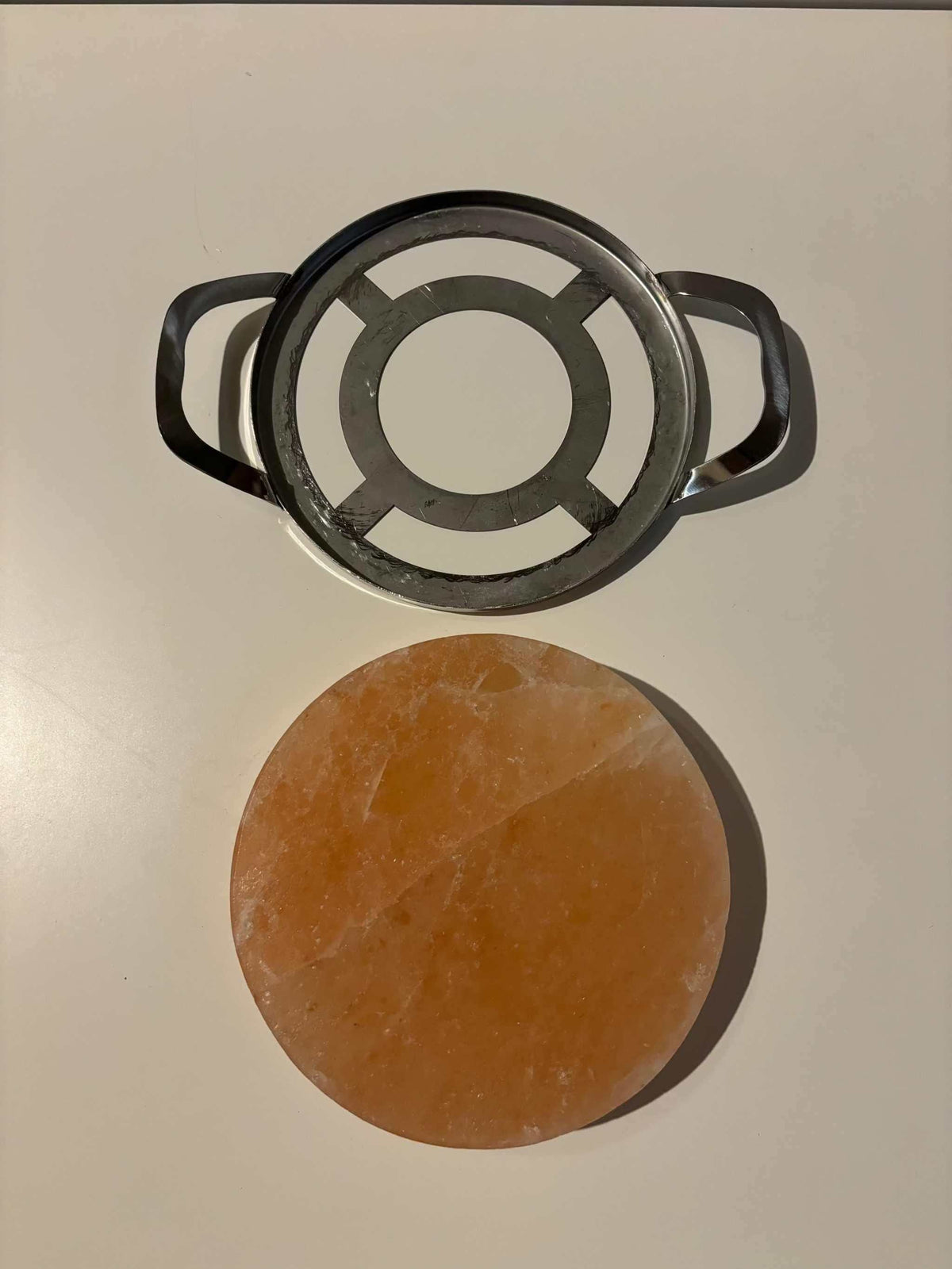 Ronde Himalaya zoutsteen kook-/serveerplaat met RVS frame, geschikt voor BBQ en oven, subtiele zoutsmaak.