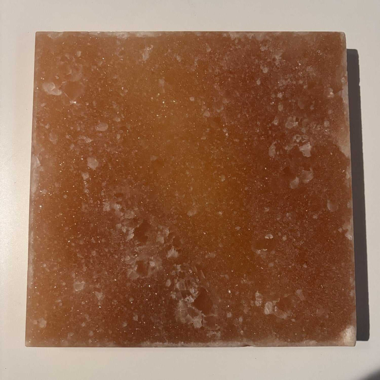 Massieve vierkante Himalaya zoutsteen tegel 20x20 cm met unieke kleurvariaties uit Khewra, ideaal als wandpaneel of sfeerverlichting.