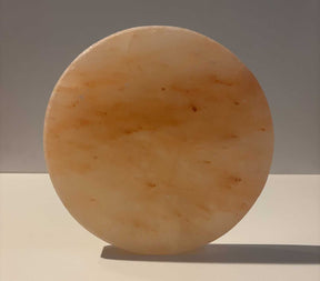 Ronde Himalaya zoutsteen tegel van 20 cm diameter met natuurlijke roze en oranje tinten.